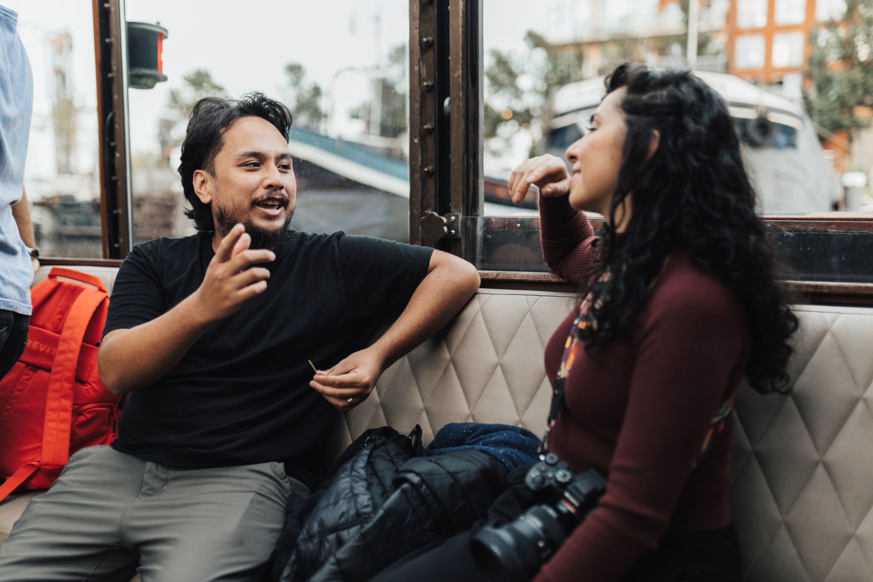 Two young people talking openly by a window